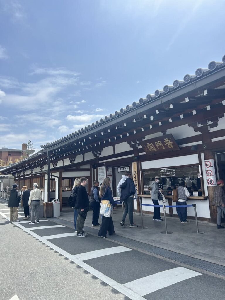 Visitors lining up at the entrance hall of a Kyoto temple entrance.